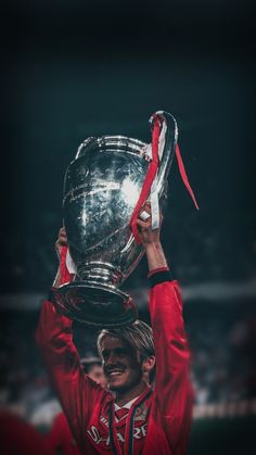 a man holding up a silver trophy on top of his head