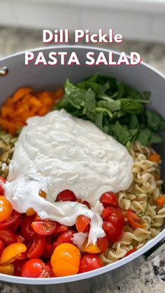 a bowl filled with pasta and vegetables on top of a marble counter topped with sour cream