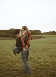 a man carrying a woman on his back in a field