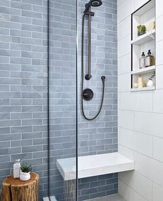 a walk in shower sitting next to a wooden table