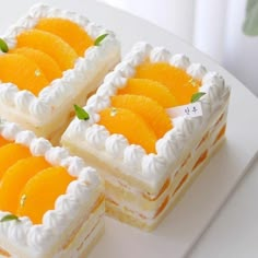 three pieces of cake with oranges on top sitting on a white plate next to each other