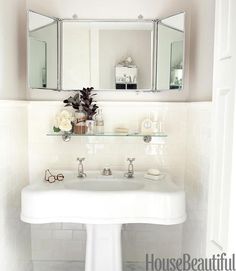 a white sink sitting under a bathroom mirror