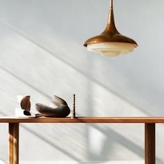 a wooden table topped with two lamps next to each other