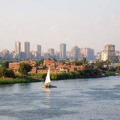 a sailboat on the river in front of a city