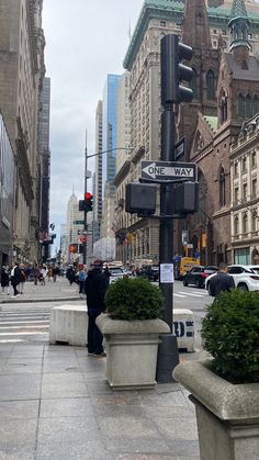 people are walking on the sidewalk in front of tall buildings and street signs that read broadway