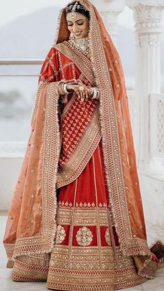 a woman in an orange and red bridal gown