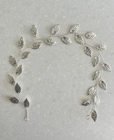 Beautiful and delicate, simple silver hair vine: silver coloured leaves wired onto silver coloured flexible wire.  Can be clipped or attached to hair in various ways, as a head band, wrapped around a bun or woven through longer hair. It has loops at each end of the wire to pin into place with hair grips, or you could attach a ribbon to tie at the nape of your neck as a hairband.  The wire is flexible so all the individual branches can be manipulated and arranged as you desire. Perfect for a wedding or other special occasion.   Approx 32-34cm long and 2-3cm wide, depending on how you adjust the branches. All my items are handmade so slight variations may occur.  Also available in gold, please see my other listings. Thank you so much for looking! x Hair Band Wedding, Silver Hair Vine, Wedding Hairband, Wedding Bridal Hair, Wedding Silver, Hair Grips, Wedding Hair Jewelry, Bridal Hair Piece, Longer Hair