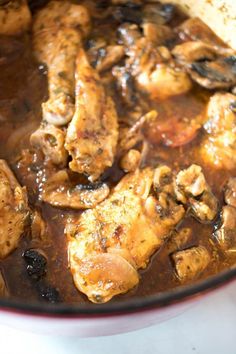 chicken and mushrooms cooking in a pot on the stove