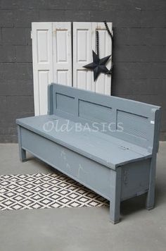 a blue bench sitting on top of a rug next to two white doors and a black star