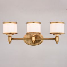 three light brass bathroom fixture with white shades