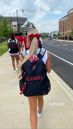 two girls walking down the sidewalk with backpacks on their back and one girl wearing a red bandana