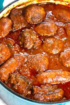 meatballs and gravy are in a pot on the stove top, ready to be cooked