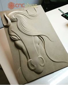 a horse head is shown on the side of a piece of paper that has been carved into it