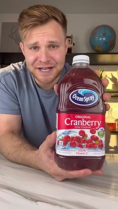 a man holding a bottle of cranberry juice