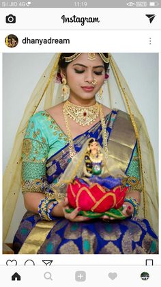 a woman in a blue and gold sari holding a red pot with an elephant on it