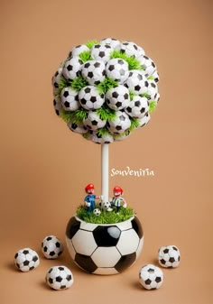 there is a soccer ball on top of a tree with little people sitting in it