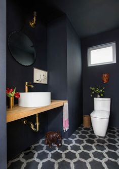 a bathroom with a toilet, sink and mirror on the wall next to a window