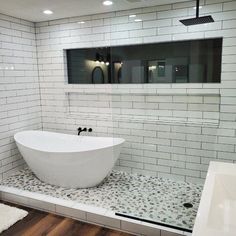 a large white bath tub sitting on top of a wooden floor