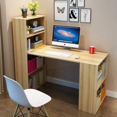 there is a desk with a computer on it and pictures above the desk, along with a chair