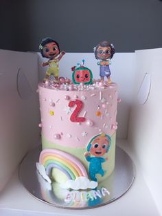 a pink and green birthday cake with cartoon characters on it