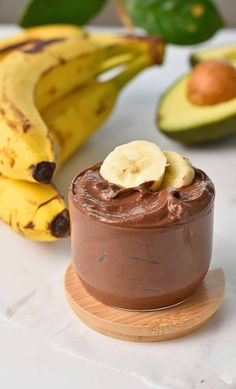 a chocolate dessert with bananas and avocado in the background