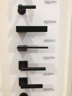 an assortment of black handles and knobs on a white wall with information about them