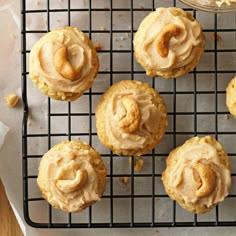 some cupcakes with frosting on a cooling rack next to a jar of peanut butter