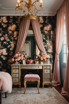 a dressing room with floral wallpaper and pink curtains on the windowsill, a gold vanity table topped with flowers