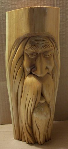 a wood carving of a bearded man with his eyes closed