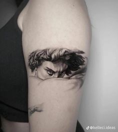 a woman's arm with a black and white tattoo on it