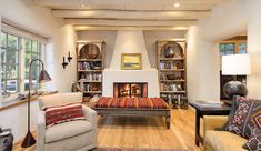 a living room filled with furniture and bookshelves next to a fire place in a fireplace