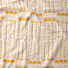 an orange and white quilted with yellow flowers on it's edges, in the shape of trees