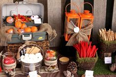 an assortment of fruits and vegetables are displayed on a table with pine cones, carrots, apples, marshmallows