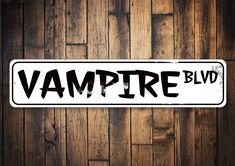 a sign that says vampire blvd on it against a wooden wall with planks