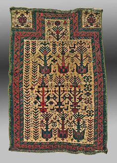 an old rug with various designs and colors on the side, including birds and arrows