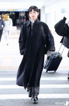 a woman walking down the street with her luggage