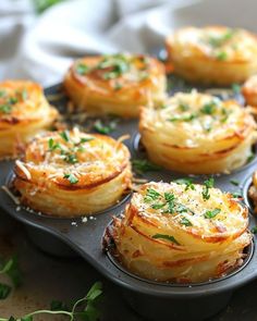 some food is sitting in a muffin tin on a table with parmesan cheese and herbs