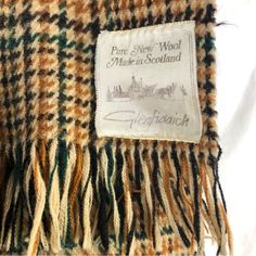 the label on this plaid blanket indicates that it is made from wool and has many different colors