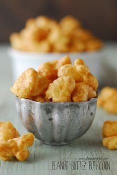 a metal bowl filled with cheese puffs on top of a table