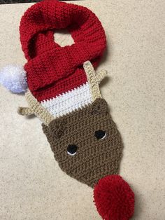 a knitted christmas stocking with a reindeer's head on it sitting on a counter