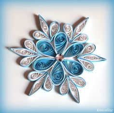 an origami snowflake made with blue and white paper