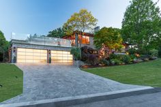 a driveway leading to a large house in the evening