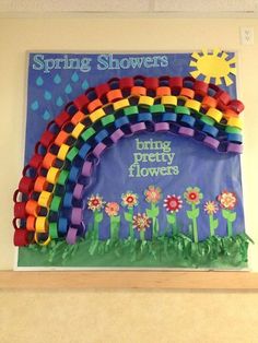 a bulletin board is decorated with flowers and a rainbow in the background that says spring showers