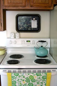 a white stove top oven sitting inside of a kitchen next to wooden cupboards and cabinets