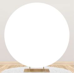 a large white ball sitting on top of a wooden floor in front of a wall