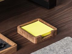 a yellow sticky pad sitting on top of a wooden desk