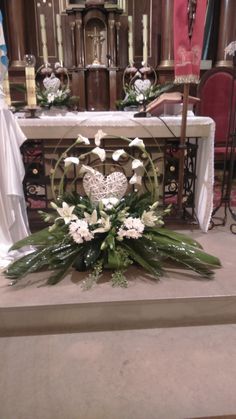 flowers and greenery are placed on the alter