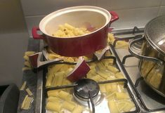 a pot on top of a stove filled with pasta