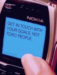 a person holding a cell phone with a message on the screen that reads get in touch with your goals, not toxic people