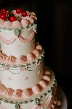 a three tiered cake with cherries on top